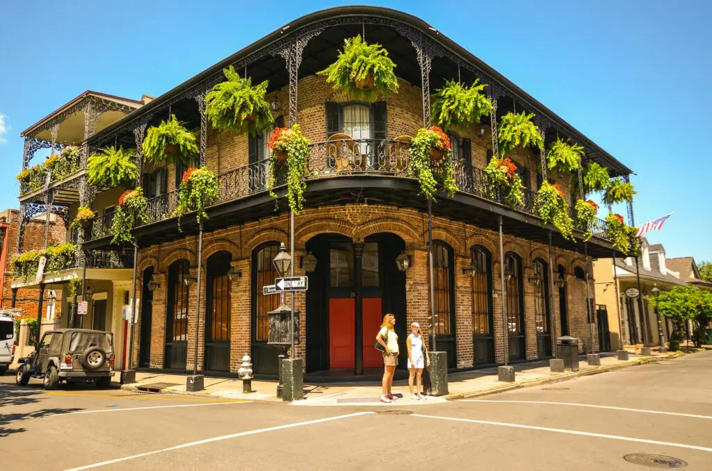 The French Quarter's elaborate cast iron balconies and colorful Mardi Gras decorations line the streets of New Orleans, a city unlike any other in America