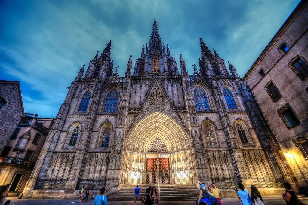 Barcelona Cathedral glows against the night sky in the Gothic Quarter, its medieval spires and ornate facade a reminder of the city's ancient foundations