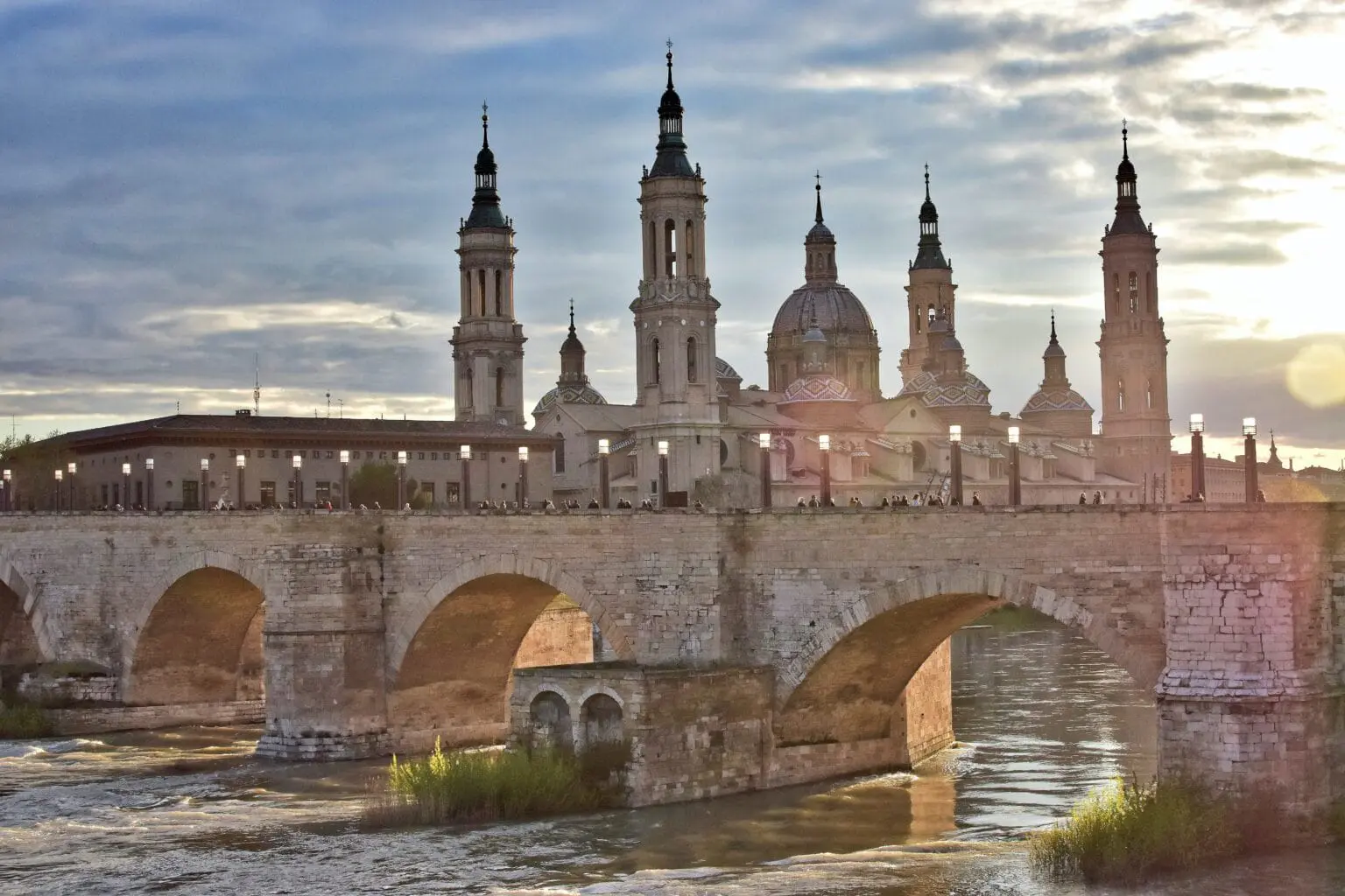 The Basilica of Our Lady of the Pillar in Zaragoza rises above the Ebro River, one of Spain's most important pilgrimage sites and a masterpiece of Baroque architecture