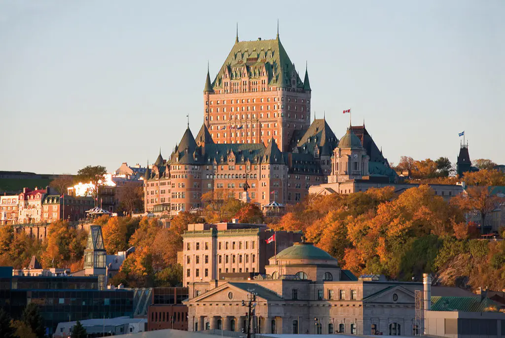 The Chateau Frontenac crowns Quebec City's Upper Town in autumn, its copper-roofed turrets rising above a sea of fall foliage and the St Lawrence River