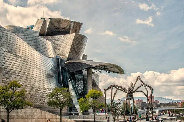 Frank Gehry's Guggenheim Museum Bilbao gleams in titanium and glass on the Nervion River, with Louise Bourgeois's giant Maman spider sculpture in the foreground