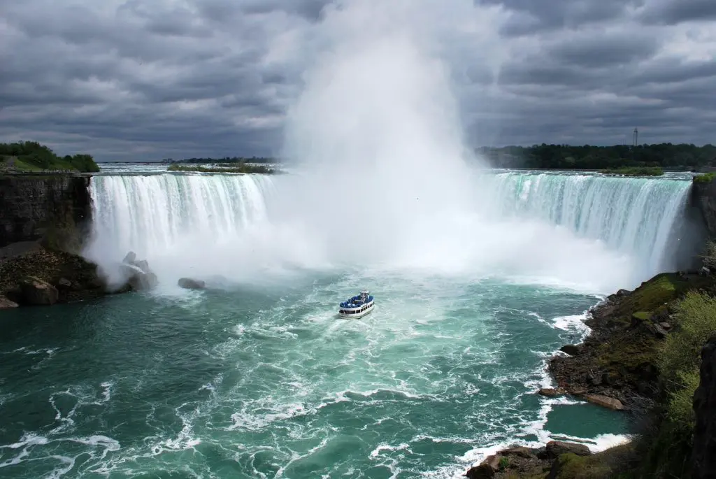 A tour boat ventures into the basin of Horseshoe Falls at Niagara, dwarfed by the sheer power of one of the world's great natural wonders