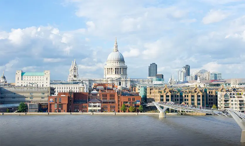 The dome of St Paul's Cathedral dominates the London skyline above the Thames, with the Millennium Bridge stretching across the foreground