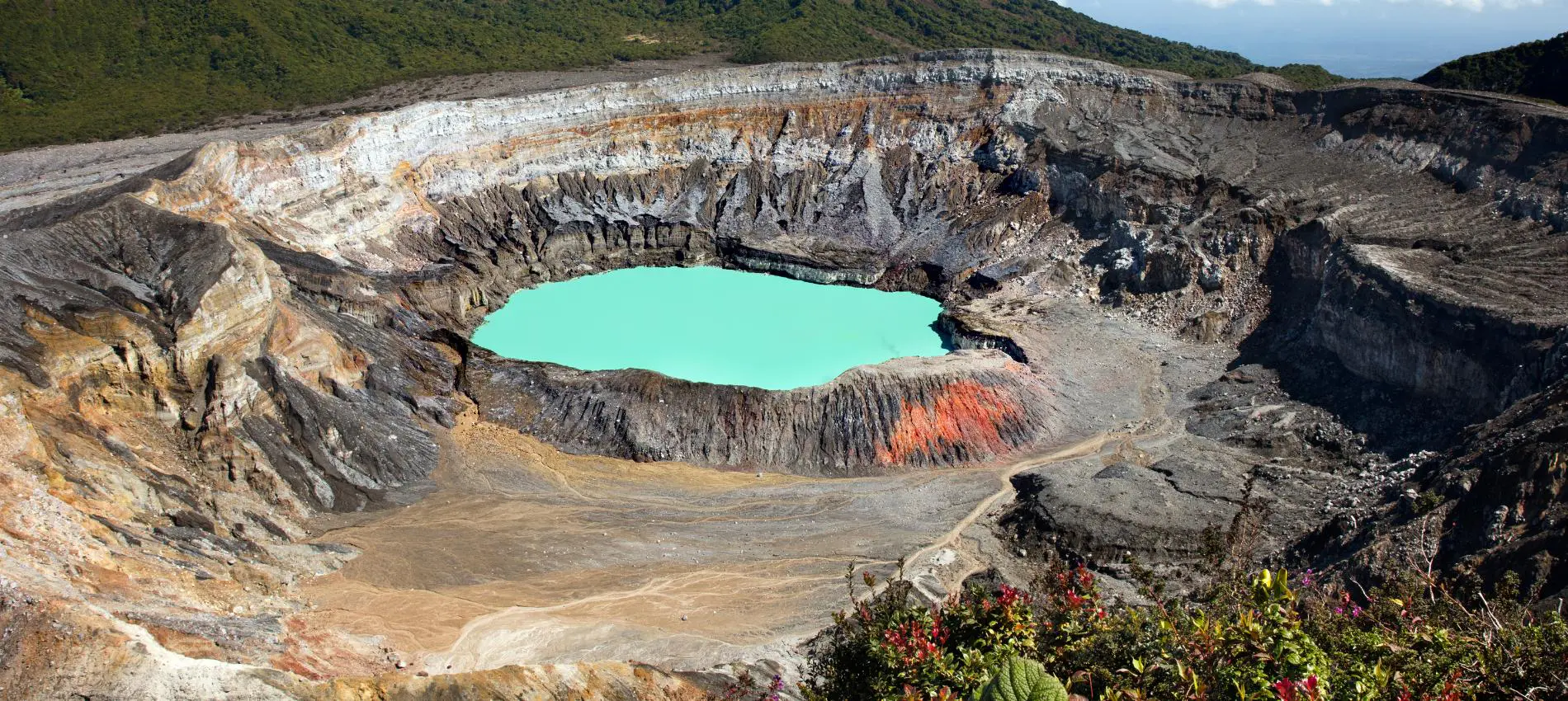 The striking turquoise crater lake of Poas Volcano in Costa Rica reveals dramatic layers of volcanic geology up close 
