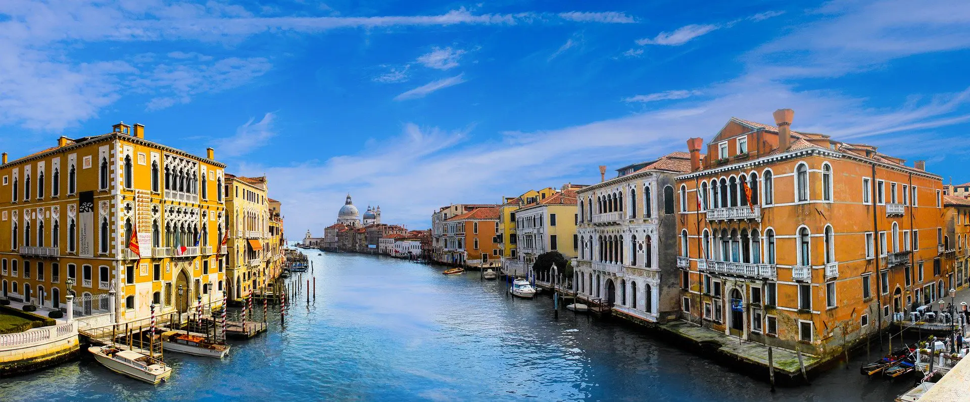 The Grand Canal winds through the heart of Venice, flanked by centuries of Renaissance and Gothic palace facades reflecting in the water
