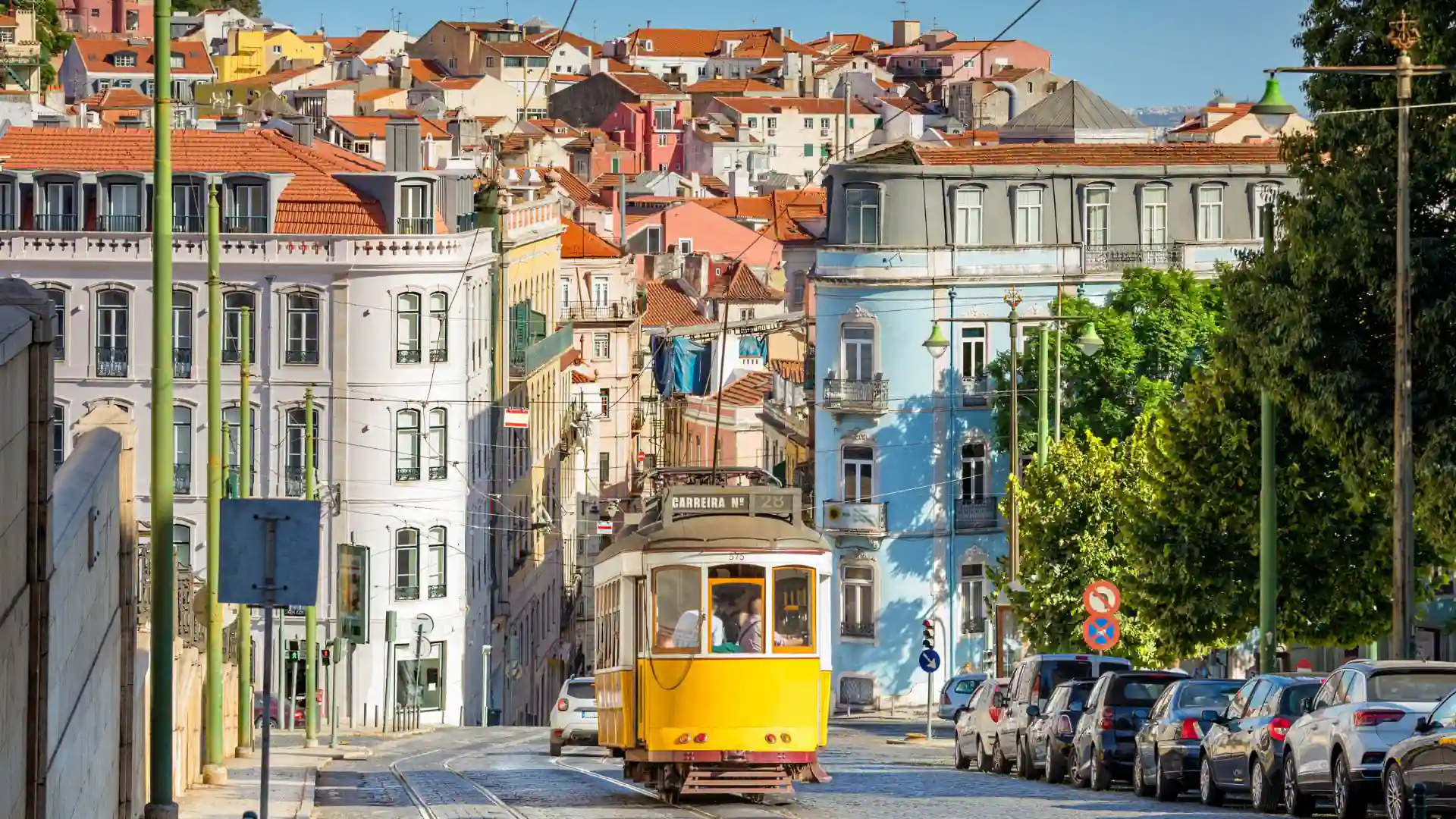 A classic yellow tram on its way past Lisbon Cathedral, on the edge of the historic Alfama district.
